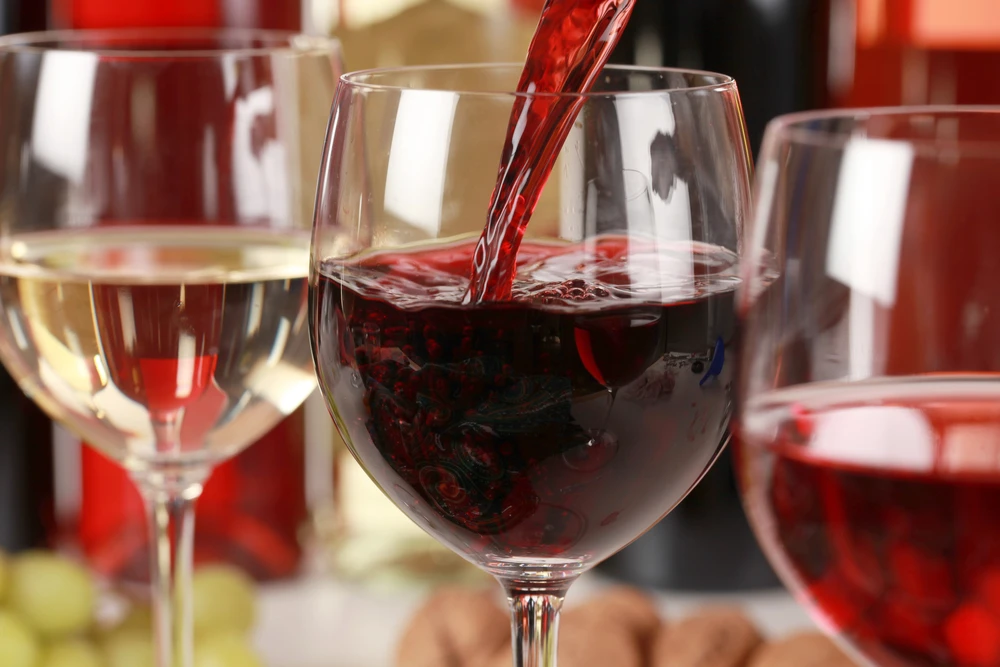 Verre de vin rouge servi à table en France, symbole de convivialité et d’art de vivre à la française lors des repas entre amis.